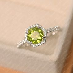 a yellow diamond ring sitting on top of a white box with diamonds around it's edges