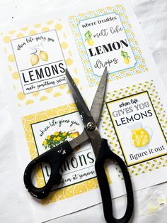 a pair of scissors sitting on top of a piece of paper next to lemons