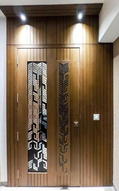 two doors with decorative designs on them in a room that has wood paneling and white walls