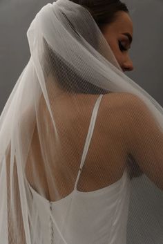 a woman wearing a white veil with her back to the camera