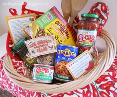 a basket filled with lots of food sitting on top of a red and white table cloth