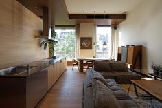 a living room filled with furniture next to a kitchen and dining room table on top of a hard wood floor