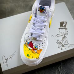 These customs are my original take on "Scrooge McDuck Money Bin"! Perfect lifestyle statement with your favorite Duckburg billionaire.  All of my customs are thoroughly prepped, spending several hours getting them ready for painting. Once ready, I use the top level industry standard Angelus Direct products. These paints allow your customs to hold up on a daily basis.  And I finally apply several sealing coats from LK Topcoat finishers. This insures the shoes are scratch and UV resistant. As well as waterproof and chemical resistant. Each custom painted takes on average 8-10 hours from start to completion. With these themed customs, you my change the base color or add / subtract elements around the shoe. While waiting for the shoes to come into the studio. I will briefly work with you to go Custom Sneakers For Streetwear, Customized Round Toe Sneakers For Streetwear, Customized Low-top Sporty Sneakers, Yellow Custom Sneakers With Artwork, Yellow Customizable Casual Sneakers, Casual Yellow Customizable Sneakers, Yellow Low-top Sneakers With Custom Artwork, Casual Customized Sneakers For Streetwear, Custom Hand Painted Yellow Sneakers