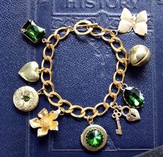 Beautiful vintage inspired bracelet with 9 solid brass and green stone charms on a chunky brass curb chain. The charms are a variety of shape and sizes  including 3 workable lockets, butterfly, flower, heart, key and lock and green rhinestones. The bracelet is made of solid brass which has been polished and sealed with numerous coats of wax, though as with all brass jewellery it will darken over time but can be repolished or left to form its natural patina as desired.  The bracelet will be supplied in a velvet gift pouch. Green Vintage Charm Brass Jewelry, Green Brass Jewelry With Vintage Charm, Green Metal Charm Bracelet, Green Metal Jewelry With Vintage Charm, Vintage Green Nickel-free Bracelet, Key And Lock, Brass Jewellery, Heart Key, Butterfly Flower