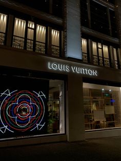 louis vuitton store front at night with colorful lights on the windows and doors