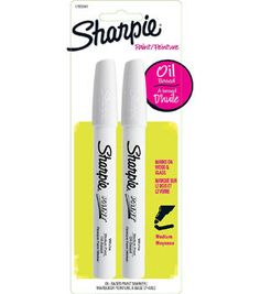 two white marker pens sitting on top of each other in front of a package with the words sharpie