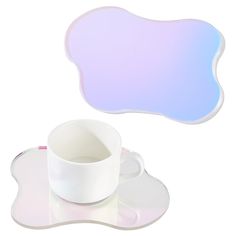 a white cup and saucer sitting on top of a table next to a plate