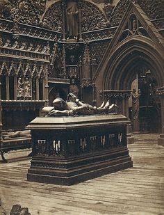 an old photo of a woman laying on top of a table in front of a building