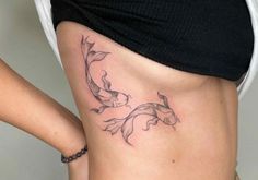 a woman's stomach with a fish tattoo on her lower body and the bottom part of her waist