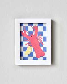 a paper cut out of a lobster on a blue and white checkerboard background