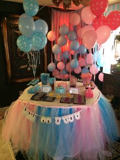 a table topped with lots of balloons and cake