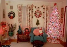 a living room decorated for christmas with a tree and other holiday decorations on the wall