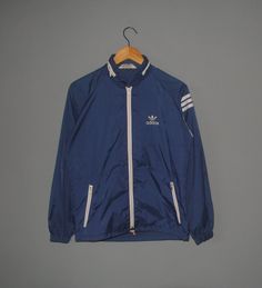 Up for sale Vintage 80s Adidas Trefoil Slim Fit light raincoat Used raincoat, Show sign of wear, Overall still in good vintage condition (Please refer picture) Tag size--Not available, Fit like Adult Small with actual measurement taken when lying flat armpit 20.5 inches and 24 inches in total lenght (Approx) Please note that vintage sizing is not the same as modern sizing. Always go by the measurements we provide and compare them to an item that fits you well. Feel free to message me for measure Hooded Three-stripes Windbreaker For Streetwear, Vintage Nylon Track Jacket For Winter, Three Stripes Windbreaker For Winter Streetwear, Vintage Windbreaker For Fall Sports, Vintage Hooded Windbreaker For Spring, Vintage Hooded Spring Windbreaker, Vintage Nylon Windbreaker For Streetwear, Outdoor Long Sleeve Windbreaker With Three Stripes, Vintage Nylon Track Jacket For Streetwear