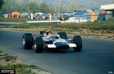 a man driving a race car down a road