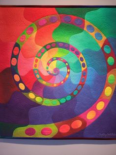 an abstract painting with many colors and shapes on the canvas, it looks like a spiral