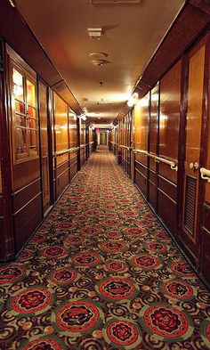 a long hallway with wooden doors and carpet