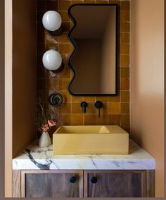 a bathroom with a sink, mirror and two lights on the wall above it's counter