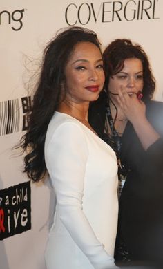 two women standing next to each other on a red carpet