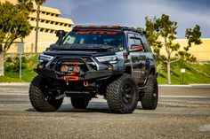 the front end of a black four - doored truck parked in a parking lot