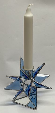 a candle holder with a blue star on it and a white candle in the middle