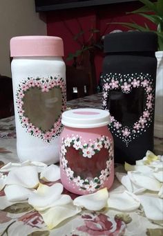 three decorated jars sitting on top of a table