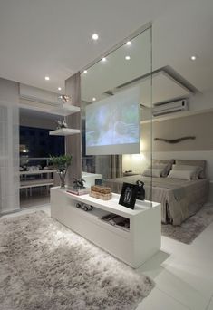 a bedroom with a large screen on the wall