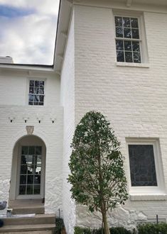 a white house with a tree in front of it