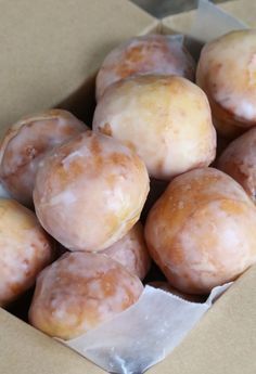 a box filled with glazed donuts sitting on top of a table