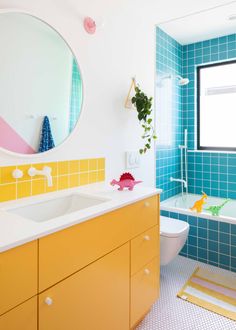 a bathroom with blue tiles and yellow cabinets