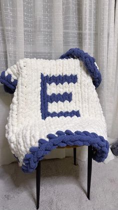 a blue and white blanket sitting on top of a chair