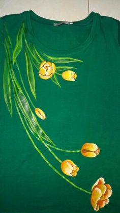 a green shirt with yellow flowers painted on it