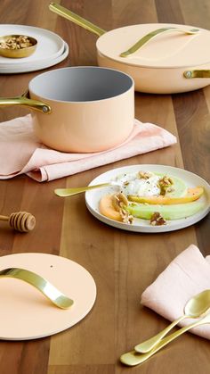 the table is set with plates, utensils and gold - plated dishes