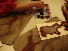 two children are making animal stencils on fabric