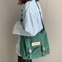 Upgrade your everyday carry with our Japanese Simple Messenger Bag. Made with high-quality materials and featuring a sleek design, this handbag is perfect for those who want both style and functionality. CLASSIC STYLE - Great for everyday use, school, college, basics, and travel accessories. CUTE ACCESSORY - It comes with an adorable removable green frog that will accompany you at all times. ROOMY - Features an extra large main compartment and front pocket, big enough for a 14 inch laptop. UPGRA Korean Bag, Waterproof Crossbody Bag, Korean Student, Postman Bag, Tas Fashion, Student Bag, Canvas Crossbody Bag, Casual Tote, Shoulder Messenger Bag