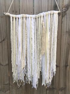 a white macrame hanging on a wooden fence