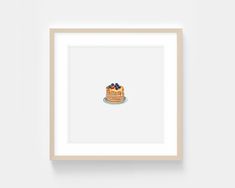 a cake with blueberries on top is framed in a wooden frame against a white wall