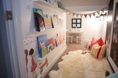 a hallway with bookshelves and children's artwork on the wall above it