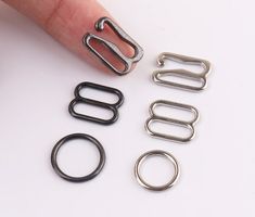 a finger is shown with several metal rings