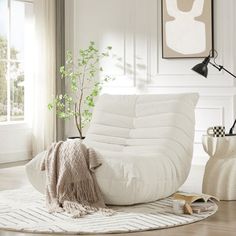 a living room filled with furniture and a potted plant on top of a rug