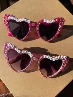 Birthday heart shaped sunglasses that all have hand glued gems and rhinestones. They have a mix of rhinestones and pearls on them. I have a pair of light pink and hot pink. I can make red, turquoise, white, black, beige and light purple also. For the colors listed you just need to message and I can have them made in 1-2 weeks. Pink Personalized Sunglasses For Gift, Personalized Pink Sunglasses As A Gift, Fun Pink Sunglasses For Gift, Fun Pink Handmade Sunglasses, Cute Red Party Sunglasses, Handmade Fun Pink Sunglasses, Fun Handmade Pink Sunglasses, Pink Heart-shaped Party Sunglasses, Cute Pink Sunglasses For Birthday