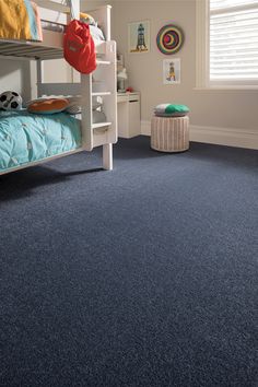 a bedroom with blue carpet and bunk beds