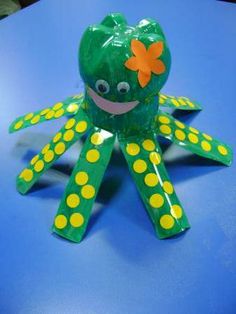 an octopus made out of green and yellow polka dots on a blue surface with a smiling face