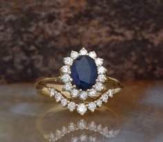 a blue and white diamond ring sitting on top of a table