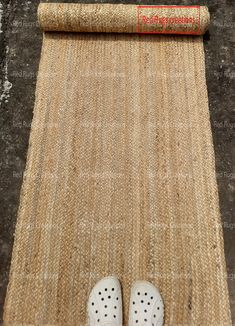 a pair of white shoes sitting on top of a rug next to a roll of paper