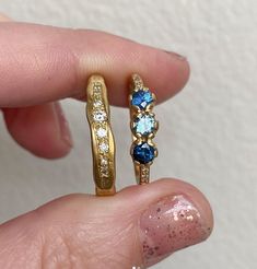 A trio of shades of mismatched deep blue sapphires with a dusting of G/VS diamonds in the band. Each sapphire measures 3.25 - 3.5mm. Diamond weight 0.03ct. Band measures 1.5mm approximately. Approximate gold weights: 1.7g in 9ct, 1.9g in 14ct, 2.1g in 18ct. Pictured here with a matte finish. For a high shine finish please leave a note at checkout. Blue Sapphire Ring With Three Stones, Fine Jewelry Blue Rings With Single Cut Diamonds, Blue Ring With Single Cut Diamonds, Fine Jewelry, 14k Gold Blue Rings With Single Cut Diamonds, Blue Sapphire Three-stone Promise Ring, Blue Sapphire Three Stone Ring With Diamonds, Blue Three Stone Sapphire Promise Ring, Blue 14k Gold Sapphire Ring With Rose Cut Diamonds, Blue Sapphire Ring With Single Cut Diamonds