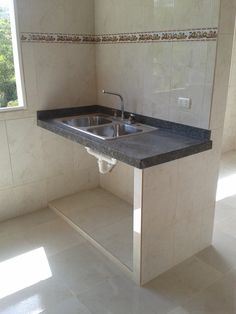 an empty kitchen with a sink and counter top in it's center area, next to a window