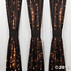 three curtains with lights on them in front of a window