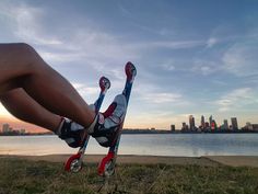 a person is upside down on skis in front of the water and city skyline