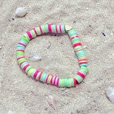 a colorful bracelet laying in the sand