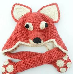 a crocheted red fox hat and mitten set with white paws on it